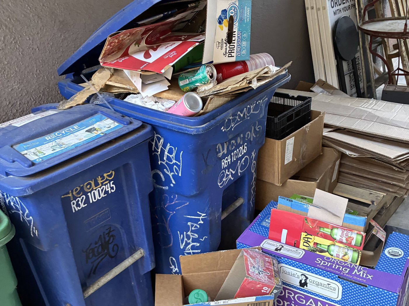 Recycling bins with sorted cardboard and mixed trash